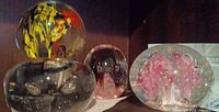 All four glass paperweights on shelf