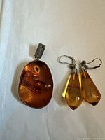Oval amber pendant and pair of amber teardrop earrings