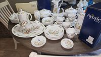Full assortment of Aynsley Cottage Garden dinnerware and serving pieces on table