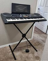 Keyboard on stand with power adapter visible