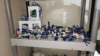 Shelf with entire assortment of blue-white ceramic ornaments, boxed and unboxed