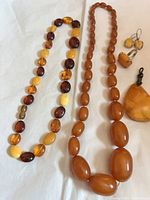 Two amber bead necklaces, pendant, earrings