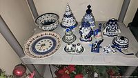Entire lot on shelf showing all ten Polish pottery pieces