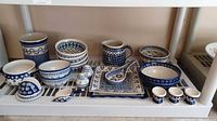 Full view of all Boleslawiec stoneware pieces arranged on shelf