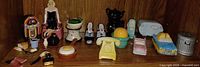 Shelf view of all ceramic novelty shakers and miniatures