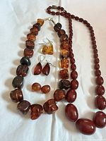 Group shot showing both necklaces, three earring pairs and loose beads