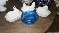 Group of four covered animal dishes showing rabbit, hen, mouse, duck