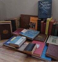 Group shot of mixed vintage books stacked and spread on floor, showing variety of bindings and approximate quantity