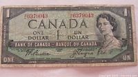 Obverse of 1954 Canadian $1 note showing portrait, denomination, serial number 6379043