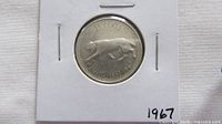 Reverse of 1967 Canadian quarter in flip showing cougar design