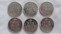 Six Canadian 50-cent coins reverse side showing Coat of Arms