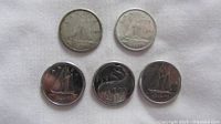 Obverse view of five Canadian dimes showing reverse designs and years