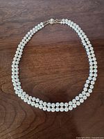 Full view of double-strand pearl necklace laid flat