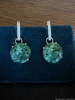 Front view of both earrings showing diamond hoops and carved jade dangles
