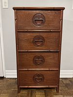Front view showing four drawers with carved Chinese pulls and bamboo-style trim