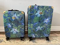 Front view of both patterned suitcases standing upright