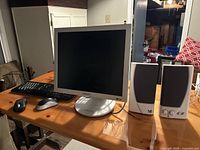 Monitor, keyboard, mouse and speakers on table