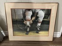 Framed Ken Danby print showing hockey player tying skates