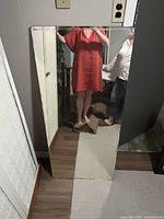 Two frameless mirrors leaning against walls showing size and edge details