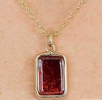 Pendant on neck displaying chain and gemstone color