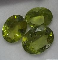 Three oval peridot gemstones close-up