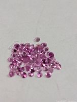 Close view of loose round pink sapphires on white background