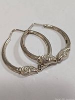 Pair of silver hoop earrings side by side