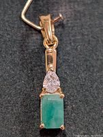 Front view of pendant showing emerald and clear stone