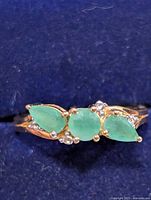 top view showing three emeralds and clear accents