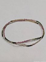 Full view of necklace coiled showing multicolor faceted beads