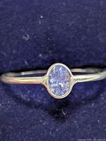 Front view of sterling silver ring featuring oval tanzanite