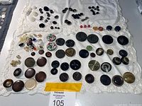 overview of entire button assortment spread on cloth showing quantity and variety