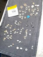 Overhead view showing entire assortment of glass and opaline buttons on mat