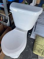Full view of white two-piece toilet showing bowl, tank and seat