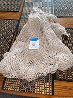 Folded crocheted tablecloth with lot tag