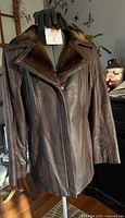 Full front view of dark brown leather jacket on mannequin