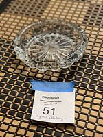 Top view of round clear crystal ashtray showing starburst pattern and faceted rim