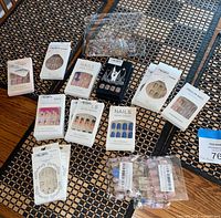 Group shot of all press-on nail packages, rhinestone packs and sticker bag