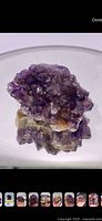 Raw amethyst crystal cluster on white background