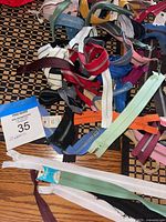 Pile of assorted colored zippers with two packaged long zippers visible