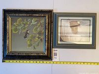 Both framed prints side by side with tape measure for width