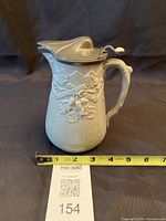 Front view of stoneware jug with ruler showing height ~7 in