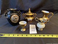 Front view of all five decorative items with tape measure for scale