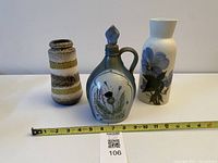 Front view of all three pottery pieces with tape for scale