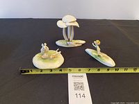 All three ceramic figurines displayed with tape measure for scale