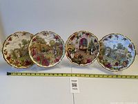 Front view of the four plates showing scenes and rose border