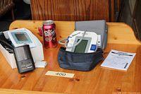 Both monitors, charger, batteries visible on wooden surface