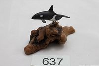 Front view showing killer whale figurine mounted on wood base with lot card