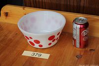 Full view of red dot mixing bowl beside soda can for scale