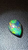 Pear-shape black opal showing multicolour play of colour